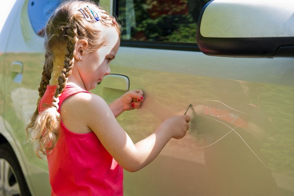 Kind verkratzt ein Auto: Bei Lackschäden durch deliktunfähige Kinder ist die Frage der Versicherungsinanspruchnahme oft besonders kompliziert (© Dron - Fotolia.com)